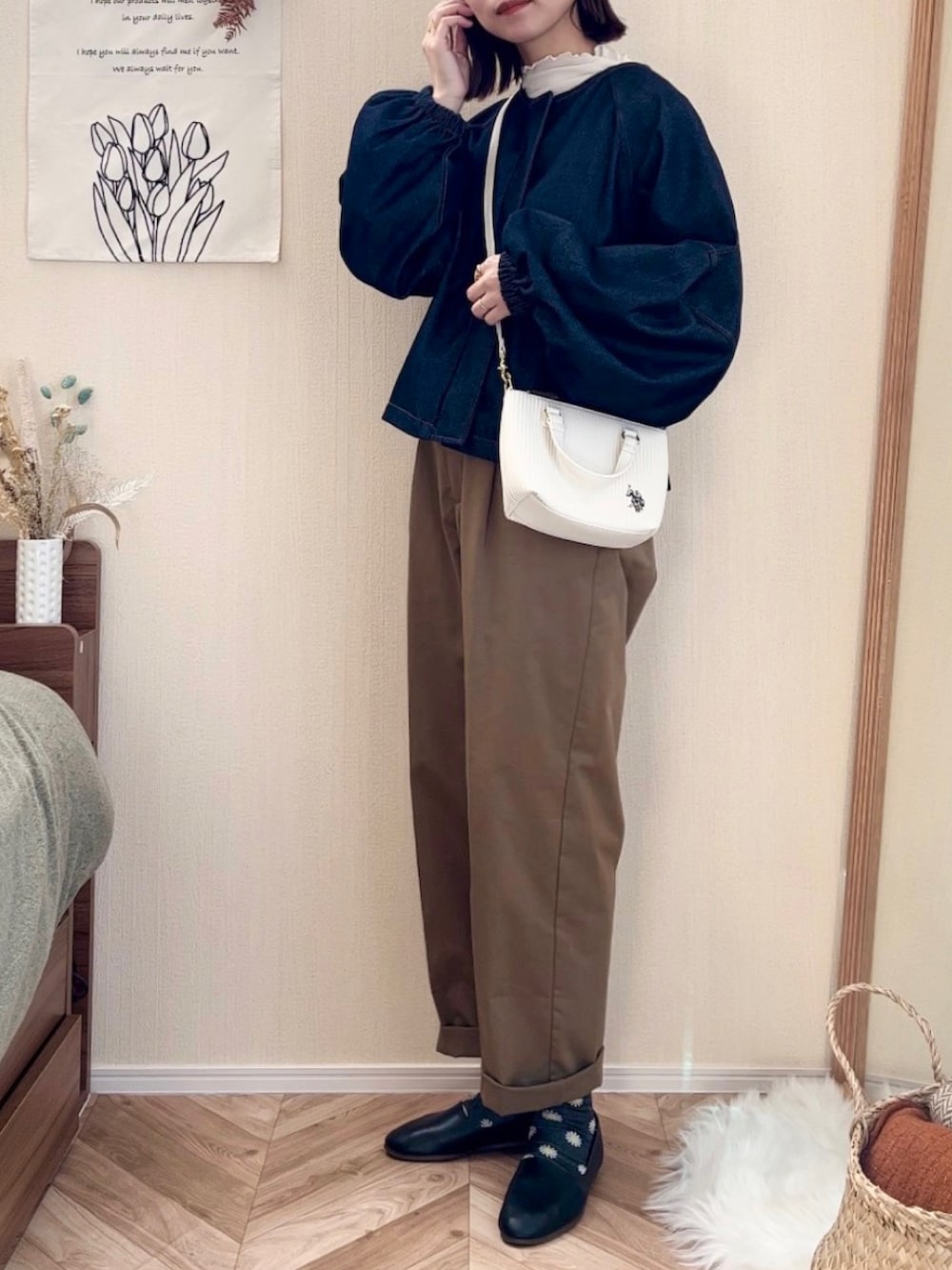 ホワイト系のショルダーバッグ、ブルー系のデニムジャケット、グリーン系のチノパンツを着用したレディースの秋コーディネートの2枚目の写真