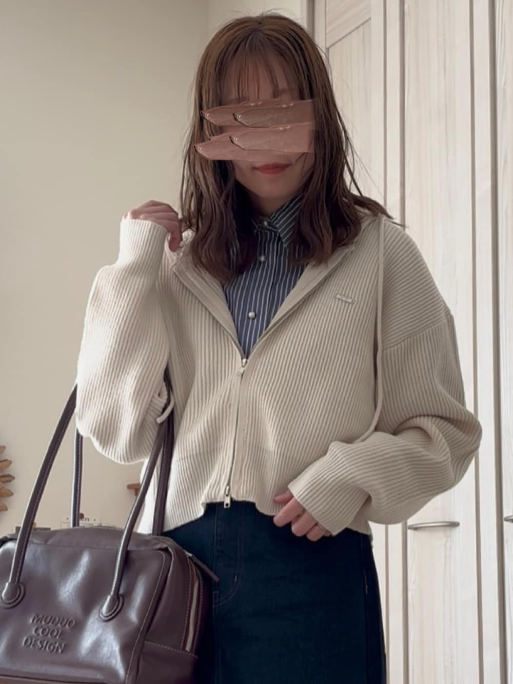 ホワイト系のパーカー、ブルー系のデニムスカートを着用したレディースの冬コーディネートの2枚目の写真