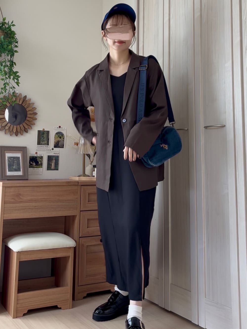 ブラウン系のテーラードジャケット、ブルー系のショルダーバッグ、ブラック系のドレスを着用したレディースの夏コーディネートの3枚目の写真