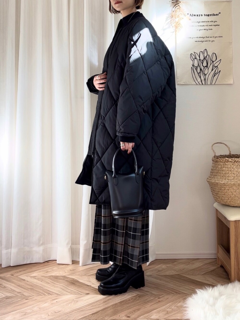 ブラック系のダウンジャケット/コート、オレンジ系のニット/セーター、ブラック系のニット/セーターを着用したレディースの冬コーディネートの3枚目の写真