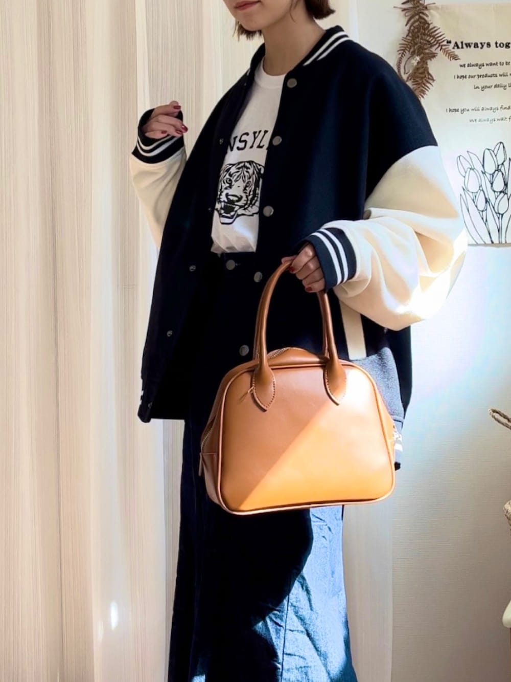 ホワイト系のTシャツ/カットソー、ブラック系のスタジャン、イエロー系のボストンバッグを着用したレディースの秋コーディネートの3枚目の写真