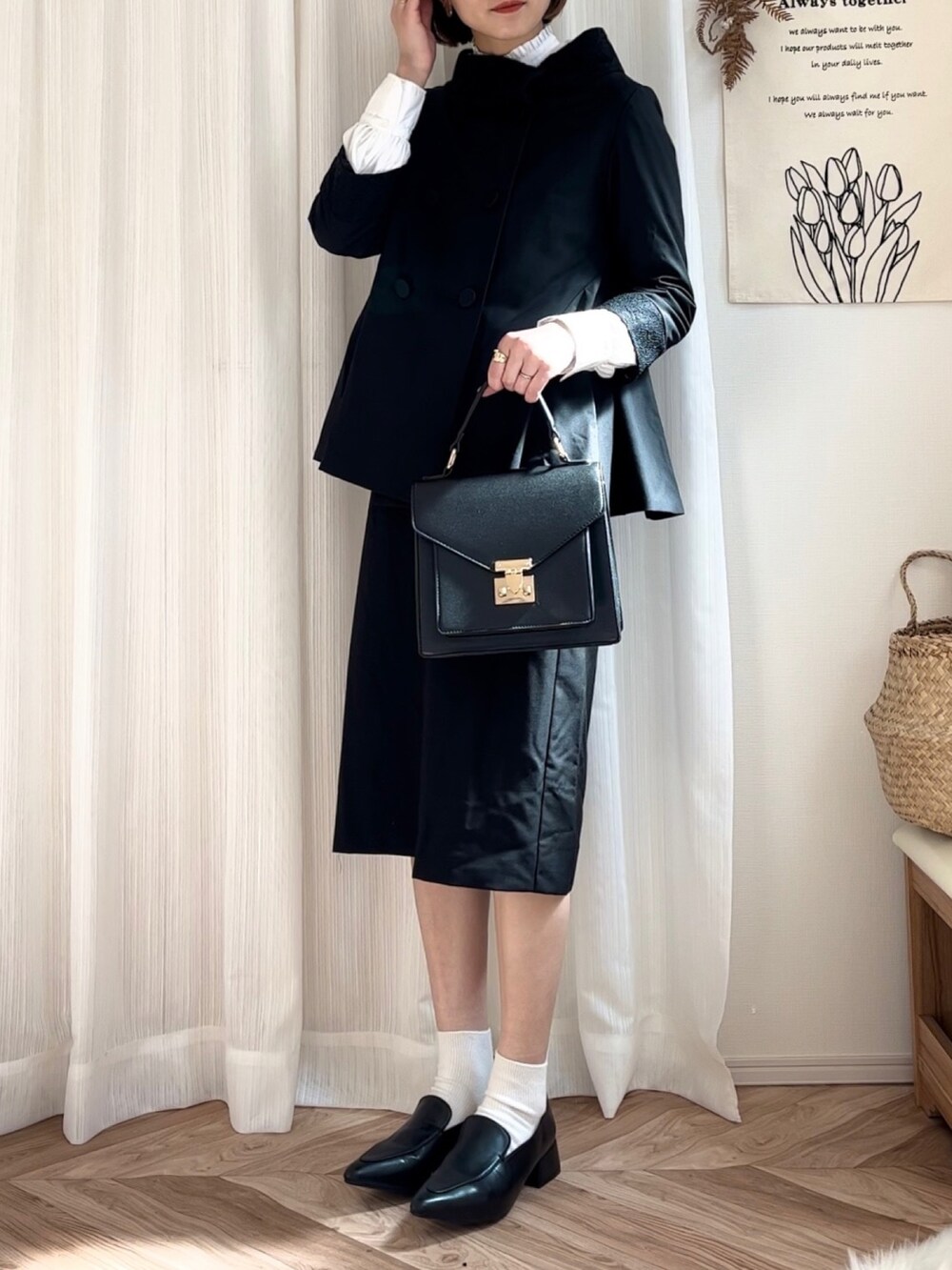 ブラック系のスーツセット、ホワイト系のシャツ/ブラウス、ブラック系のローファーを着用したレディースの春コーディネートの3枚目の写真