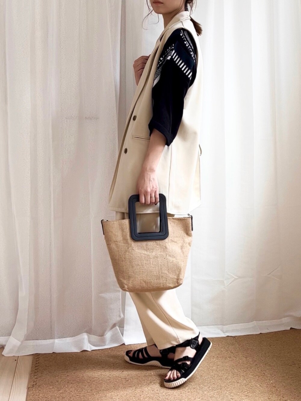 ブラック系のニット/セーター、ホワイト系のその他パンツ、ブラック系のサンダルを着用したレディースの夏コーディネートの2枚目の写真