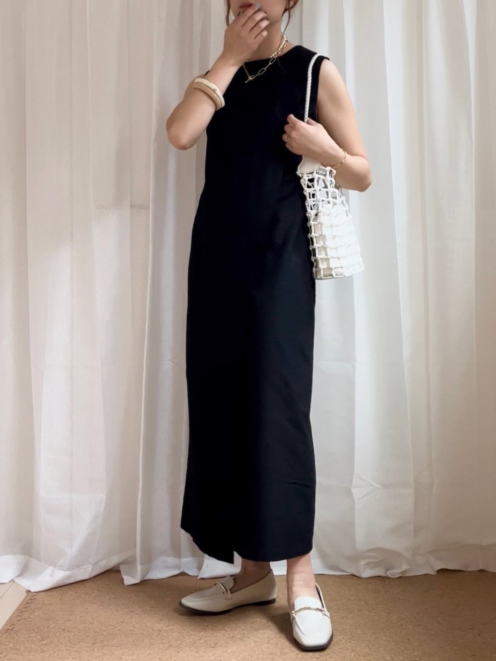 ブラック系のワンピース、ホワイト系のローファー、ホワイト系のネックレスを着用したレディースの春コーディネートの2枚目の写真