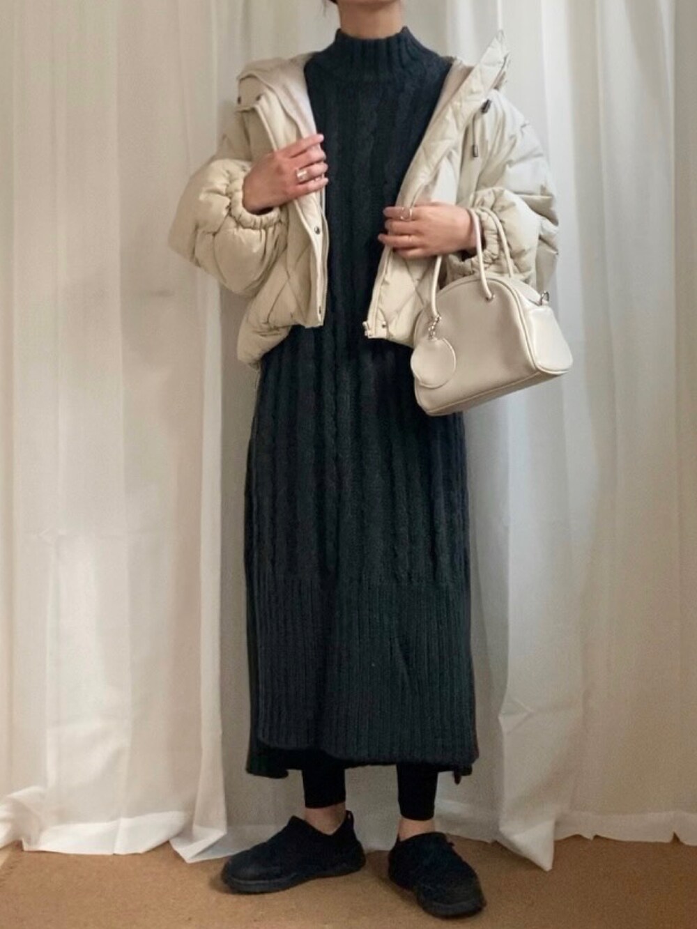 ホワイト系のダウンジャケット/コート、グレー系のワンピース、ホワイト系のボストンバッグを着用したレディースの冬コーディネートの2枚目の写真