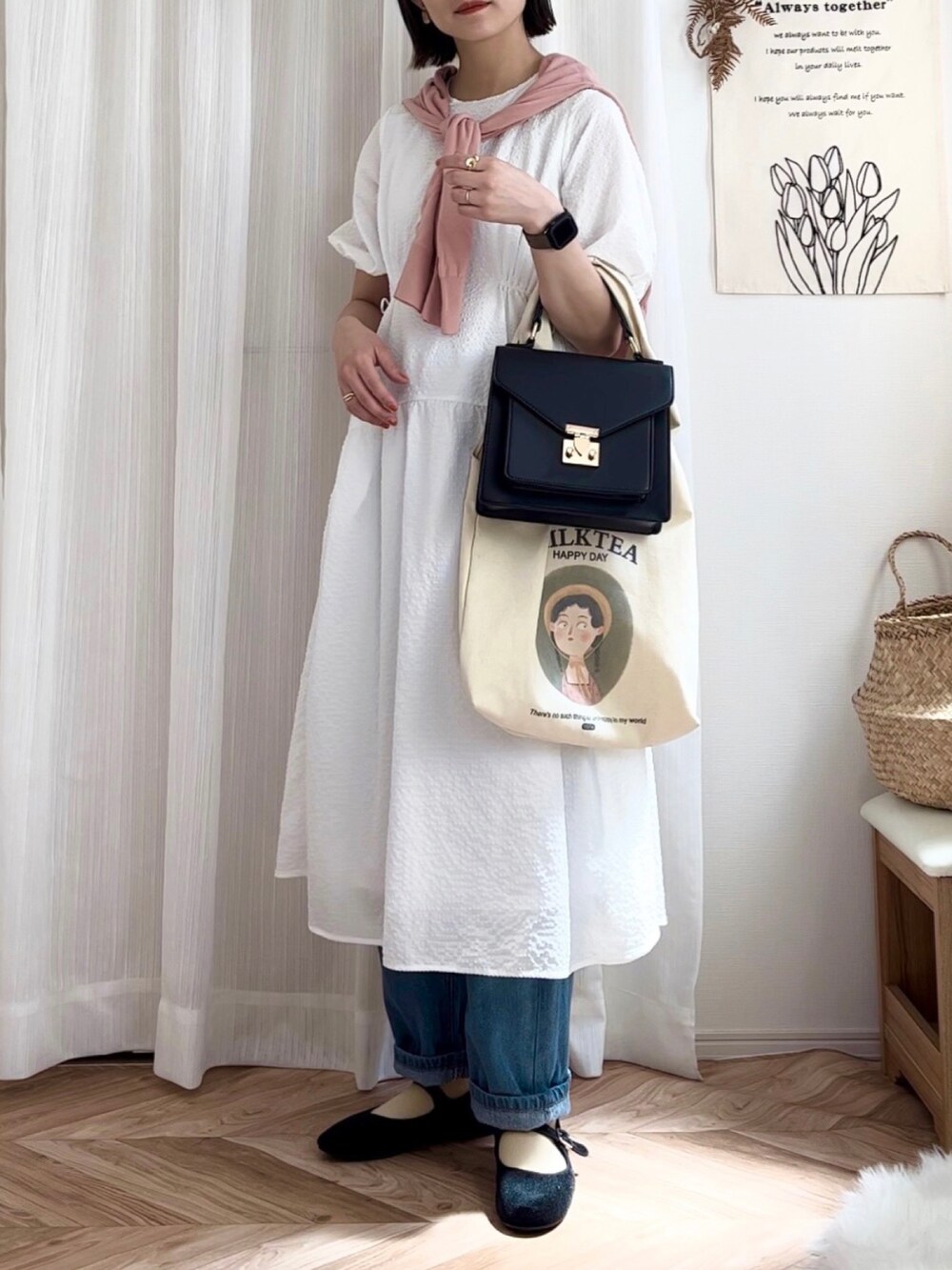 ホワイト系のワンピース、ブルー系のデニムパンツ、ブラック系のバレエシューズを着用したレディースの春コーディネートの2枚目の写真