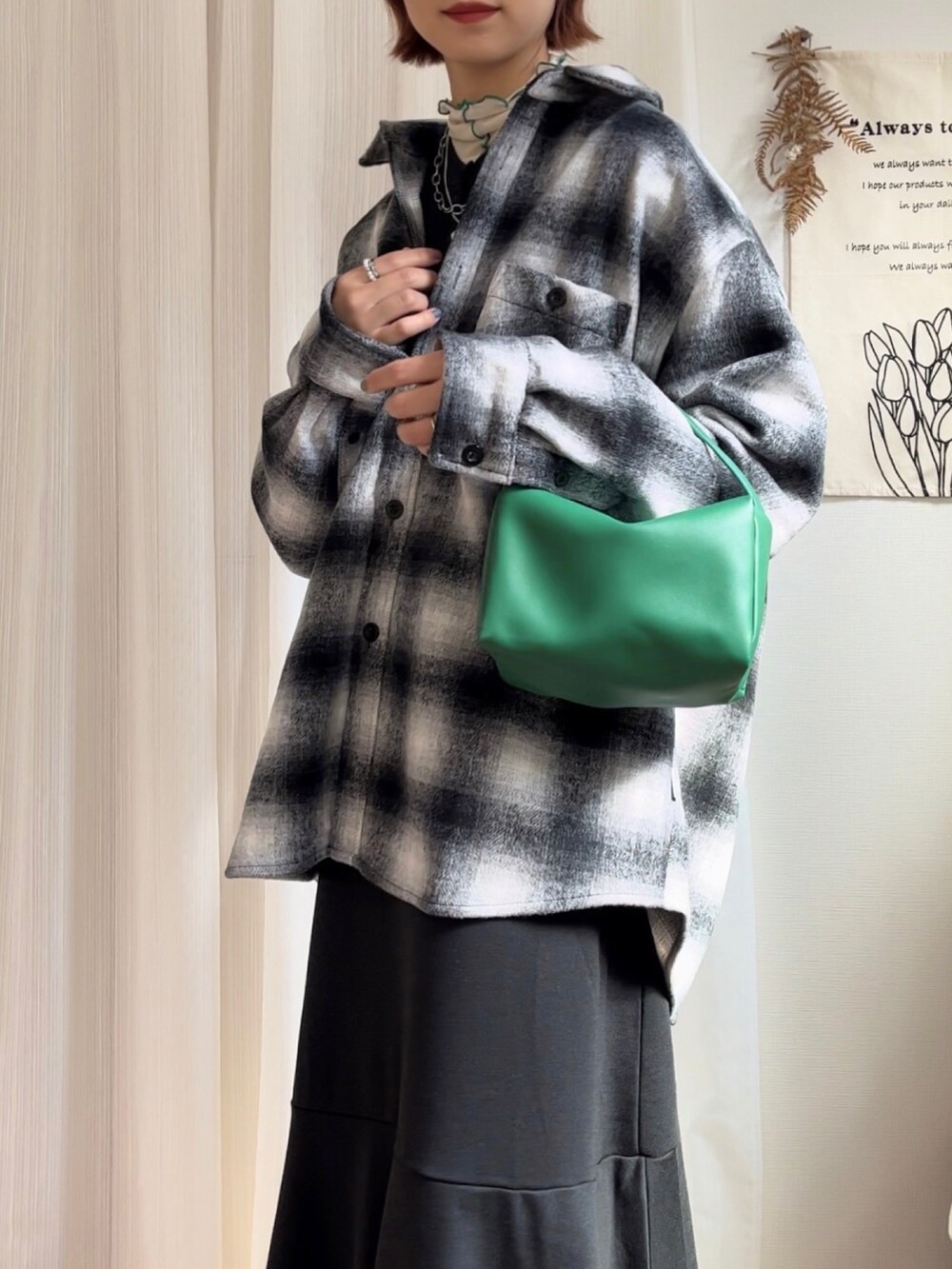 ブラック系のその他アウター、ブラック系のワンピース、ホワイト系のTシャツ/カットソーを着用したレディースの秋コーディネートの2枚目の写真