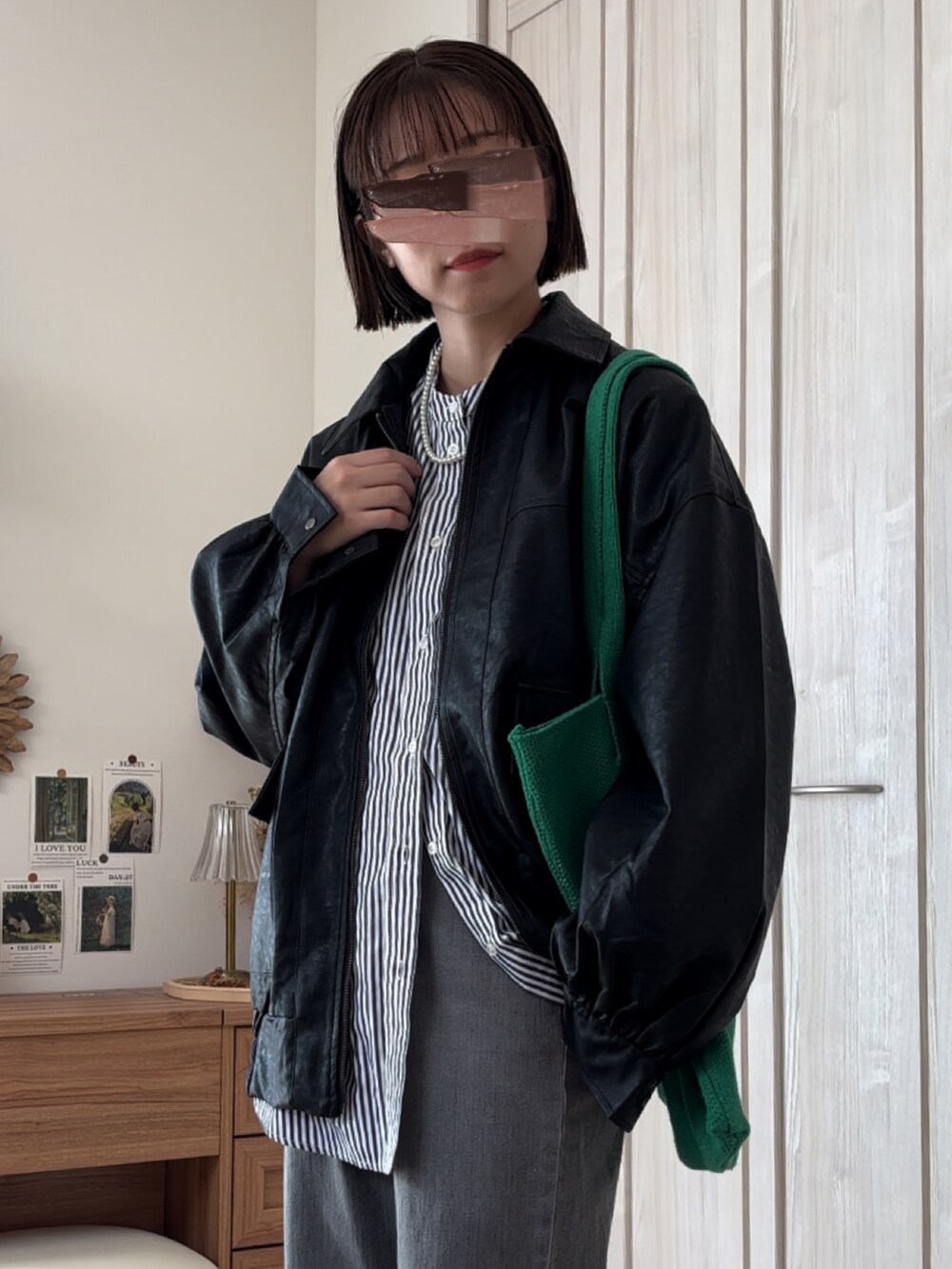 ブラック系のブルゾン、ブルー系のシャツ/ブラウス、グレー系のデニムパンツを着用したレディースの秋コーディネートの3枚目の写真