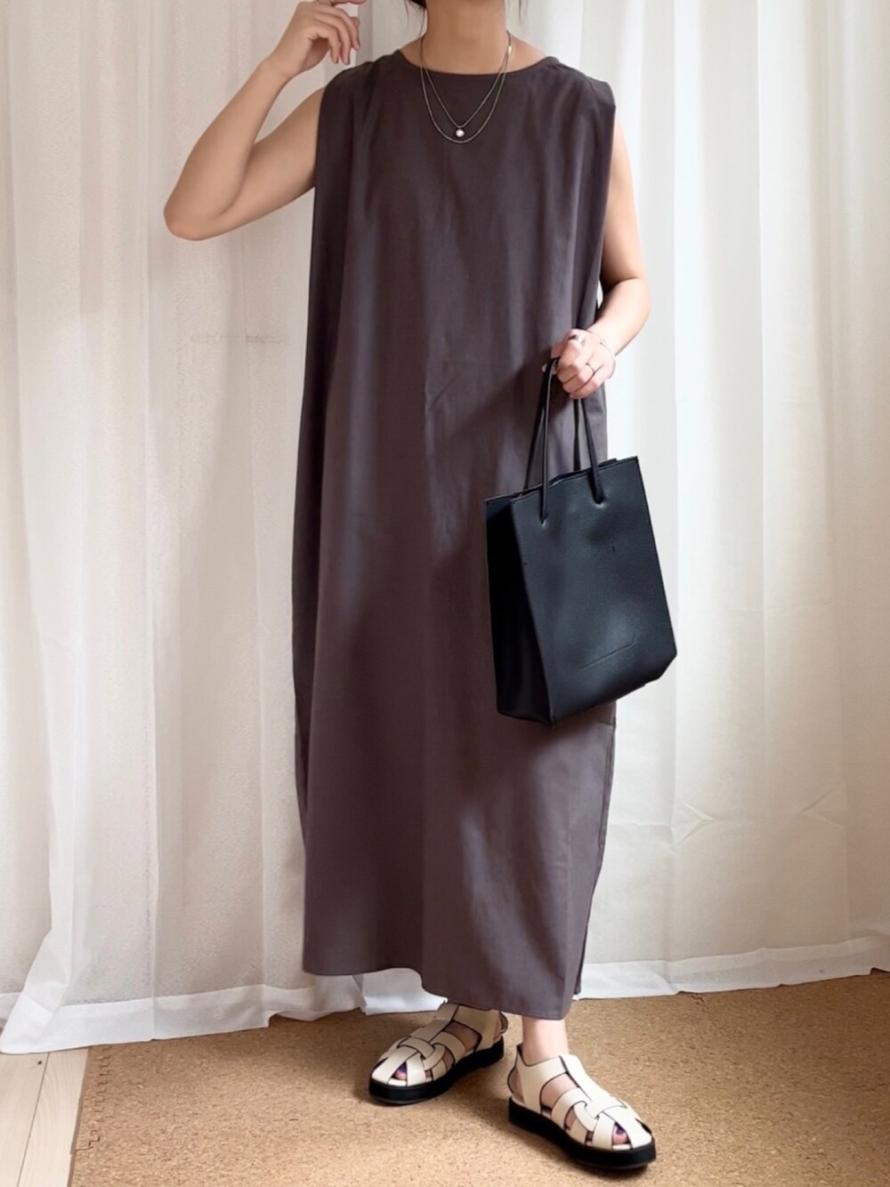グレー系のワンピース、ブラック系のトートバッグ、ベージュ系のサンダルを着用したレディースの夏コーディネートの3枚目の写真