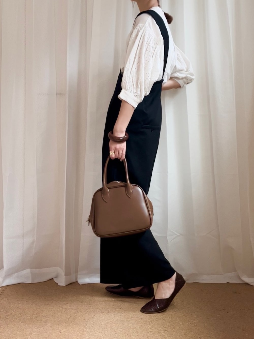 ホワイト系のシャツ/ブラウス、ブラック系のサロペット/オーバーオール、ブラウン系のボストンバッグを着用したレディースの春コーディネートの2枚目の写真