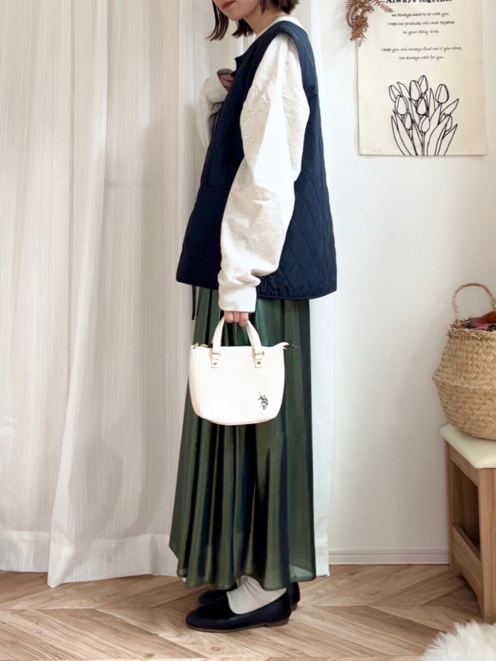 ベージュ系のスウェット、グリーン系のスカート、ホワイト系のショルダーバッグを着用したレディースの秋コーディネートの2枚目の写真