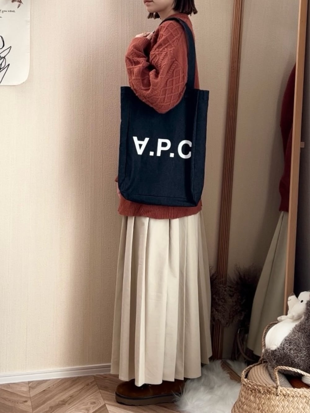 オレンジ系のニット/セーター、ベージュ系のデニムスカート、イエロー系のモカシン/デッキシューズを着用したレディースの秋コーディネートの4枚目の写真