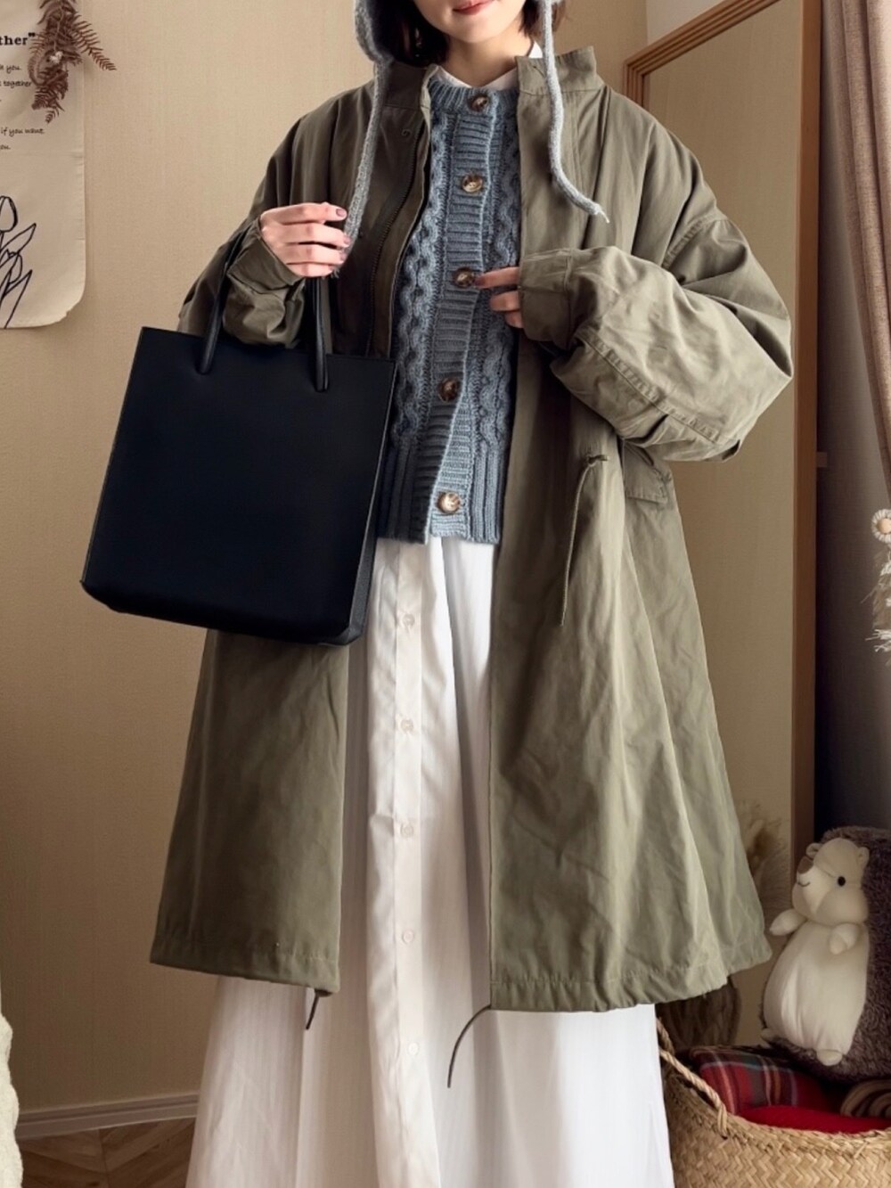 グリーン系のモッズコート、ブルー系のカーディガン/ボレロ、ホワイト系のシャツワンピースを着用したレディースの冬コーディネートの3枚目の写真