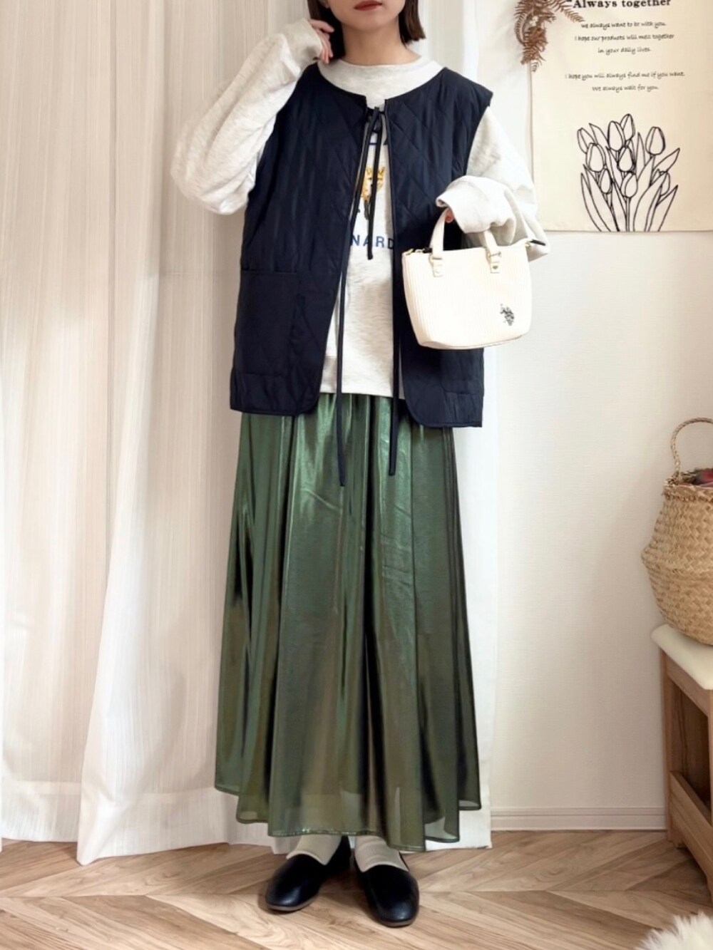 ベージュ系のスウェット、グリーン系のスカート、ホワイト系のショルダーバッグを着用したレディースの秋コーディネートの3枚目の写真