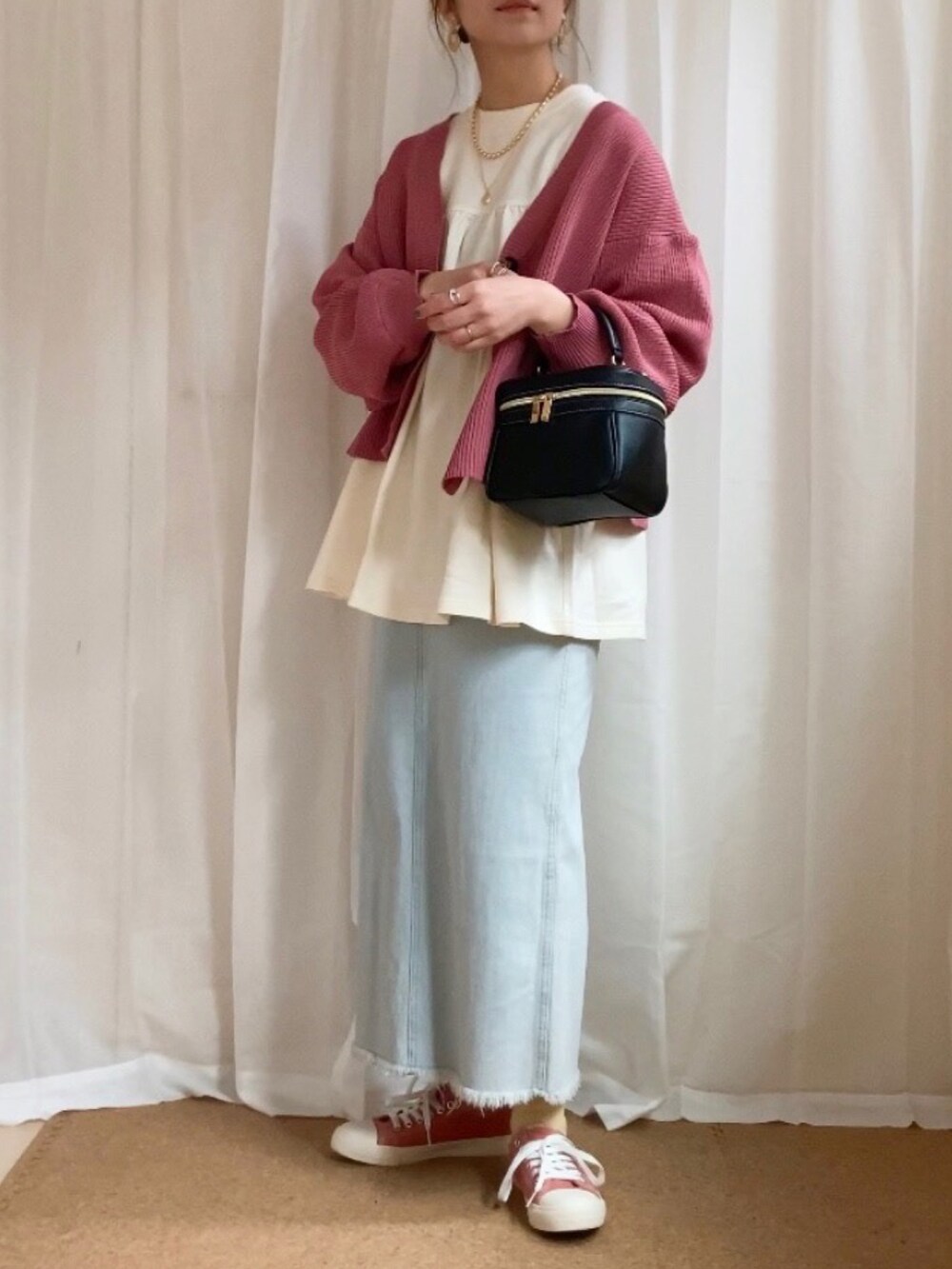 ホワイト系のTシャツ/カットソー、ピンク系のカーディガン/ボレロ、ブルー系のスカートを着用したレディースの春コーディネートの3枚目の写真