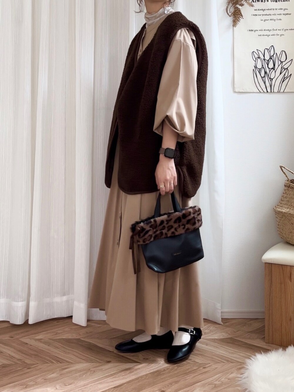 ブラウン系のベスト、ベージュ系のシャツワンピース、ベージュ系のTシャツ/カットソーを着用したレディースの秋コーディネートの2枚目の写真