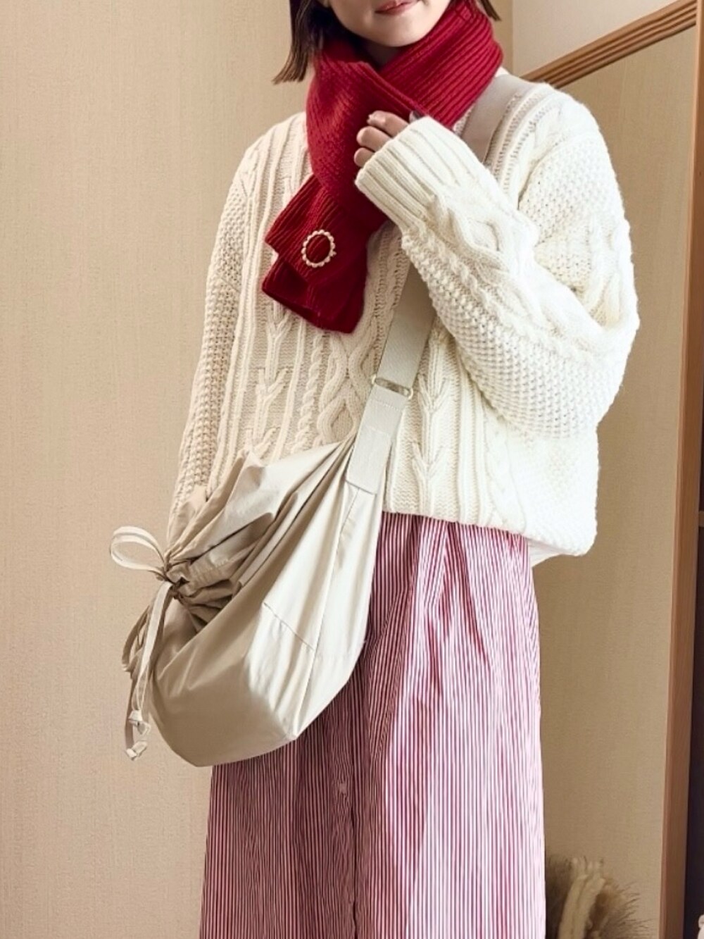 ベージュ系のニット/セーター、レッド系のシャツワンピース、ブラック系のノーカラーコートを着用したレディースの冬コーディネートの4枚目の写真