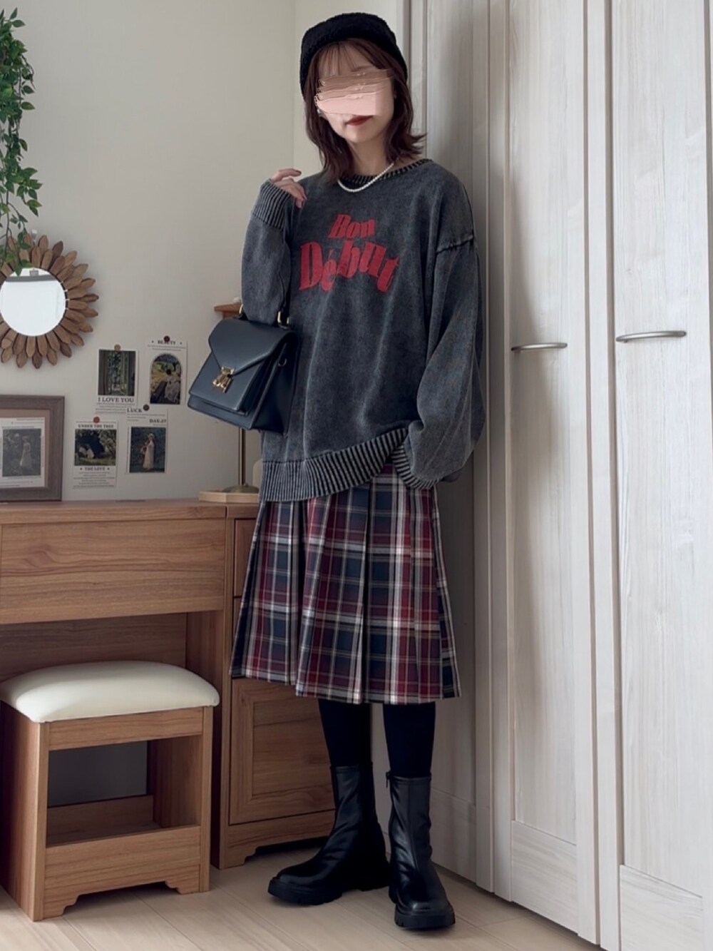 ブラック系のニット/セーター、ブラック系のブーツ、ブルー系のスカートを着用したレディースの秋コーディネートの4枚目の写真