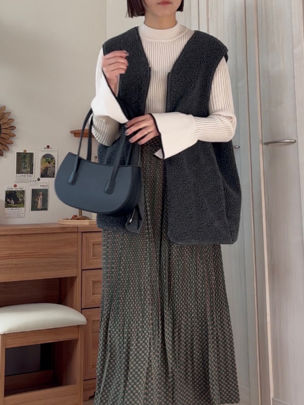 グリーン系のスカート、ホワイト系のニット/セーター、グレー系のベストを着用したレディースの冬コーディネートの4枚目の写真