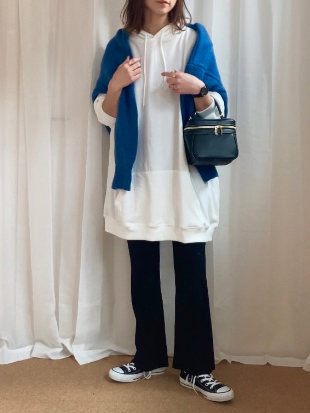 ホワイト系のパーカー、ブルー系のニット/セーター、ブラック系のバッグを着用したレディースの冬コーディネートの2枚目の写真