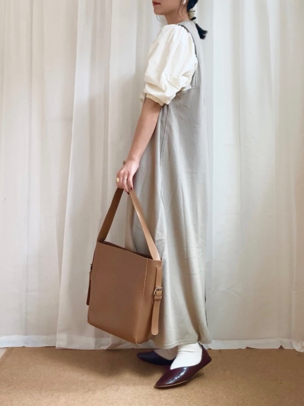 グリーン系のワンピース、ブラウン系のトートバッグ、ブラウン系のパンプスを着用したレディースの春コーディネートの2枚目の写真