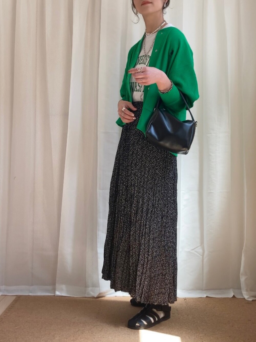 ホワイト系のTシャツ/カットソー、グリーン系のカーディガン/ボレロ、ブラック系のショルダーバッグを着用したレディースの春コーディネートの2枚目の写真