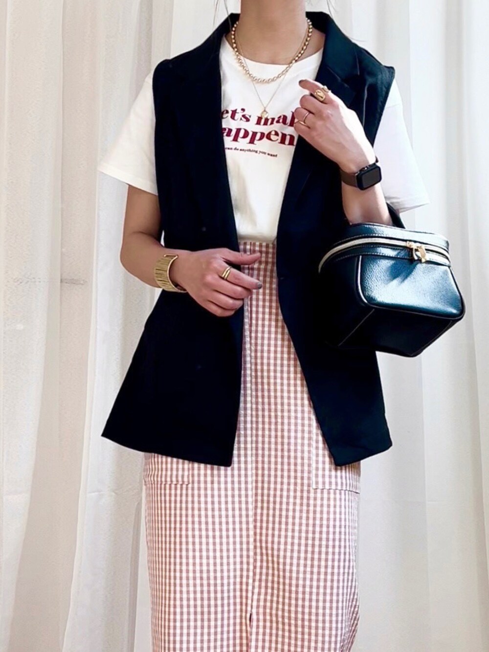 ホワイト系のTシャツ/カットソー、ブラック系のベスト、ピンク系のスカートを着用したレディースの春コーディネートの2枚目の写真