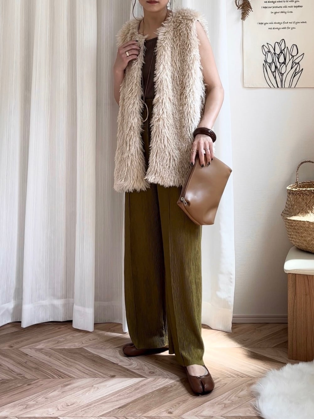 ホワイト系のベスト、ブラウン系のパンプス、ブラウン系のバングル/リストバンドを着用したレディースの夏コーディネートの2枚目の写真