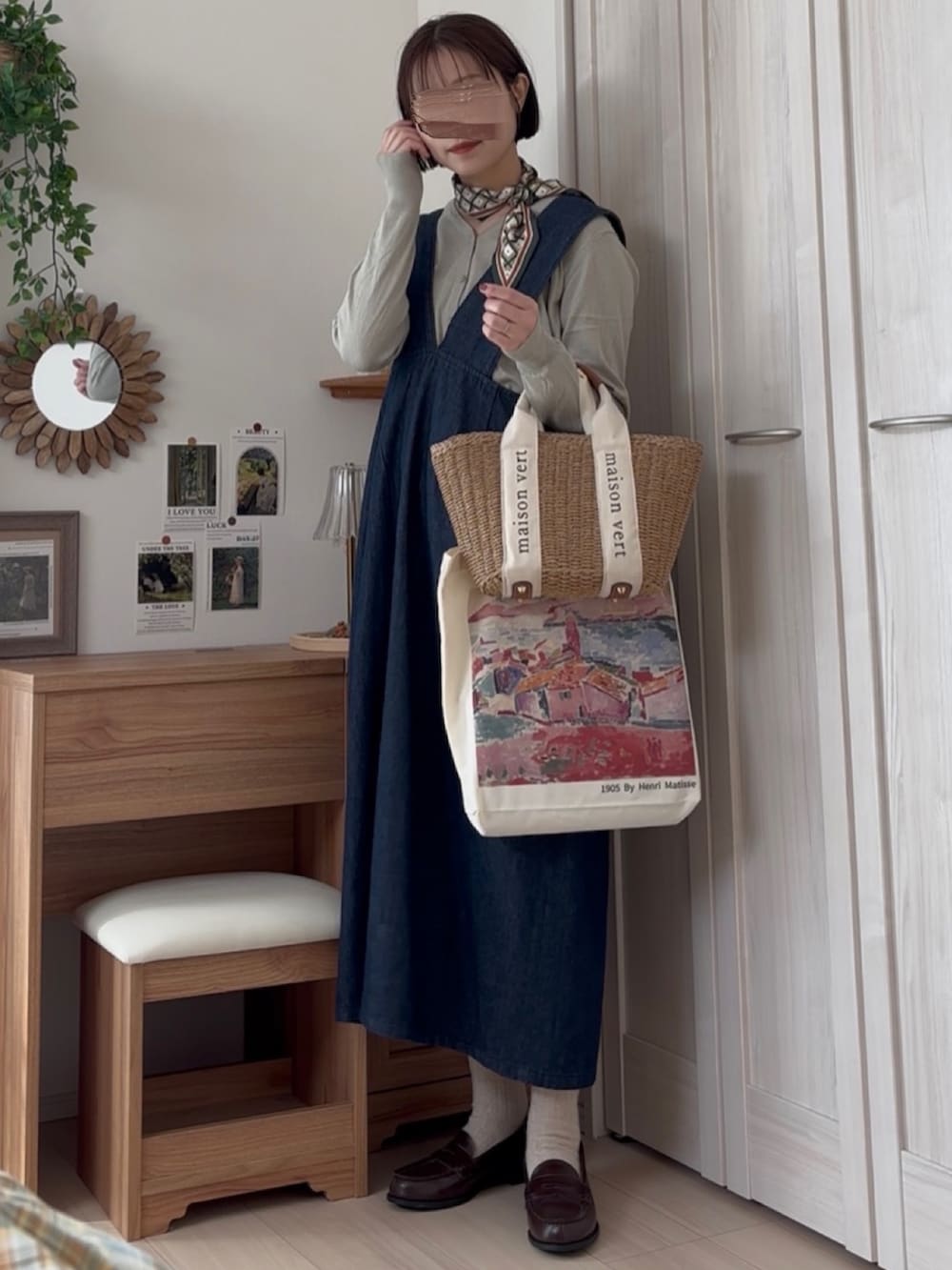 グリーン系のカーディガン/ボレロ、ブルー系のジャンパースカートを着用したレディースの冬コーディネートの2枚目の写真