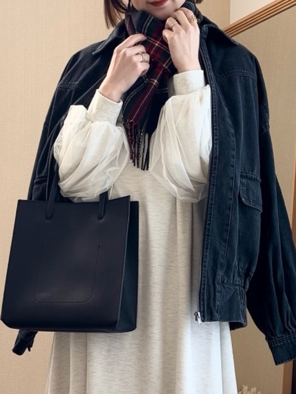 ブラック系のブルゾン、グレー系のワンピース、ブラック系のトートバッグを着用したレディースの冬コーディネートの2枚目の写真