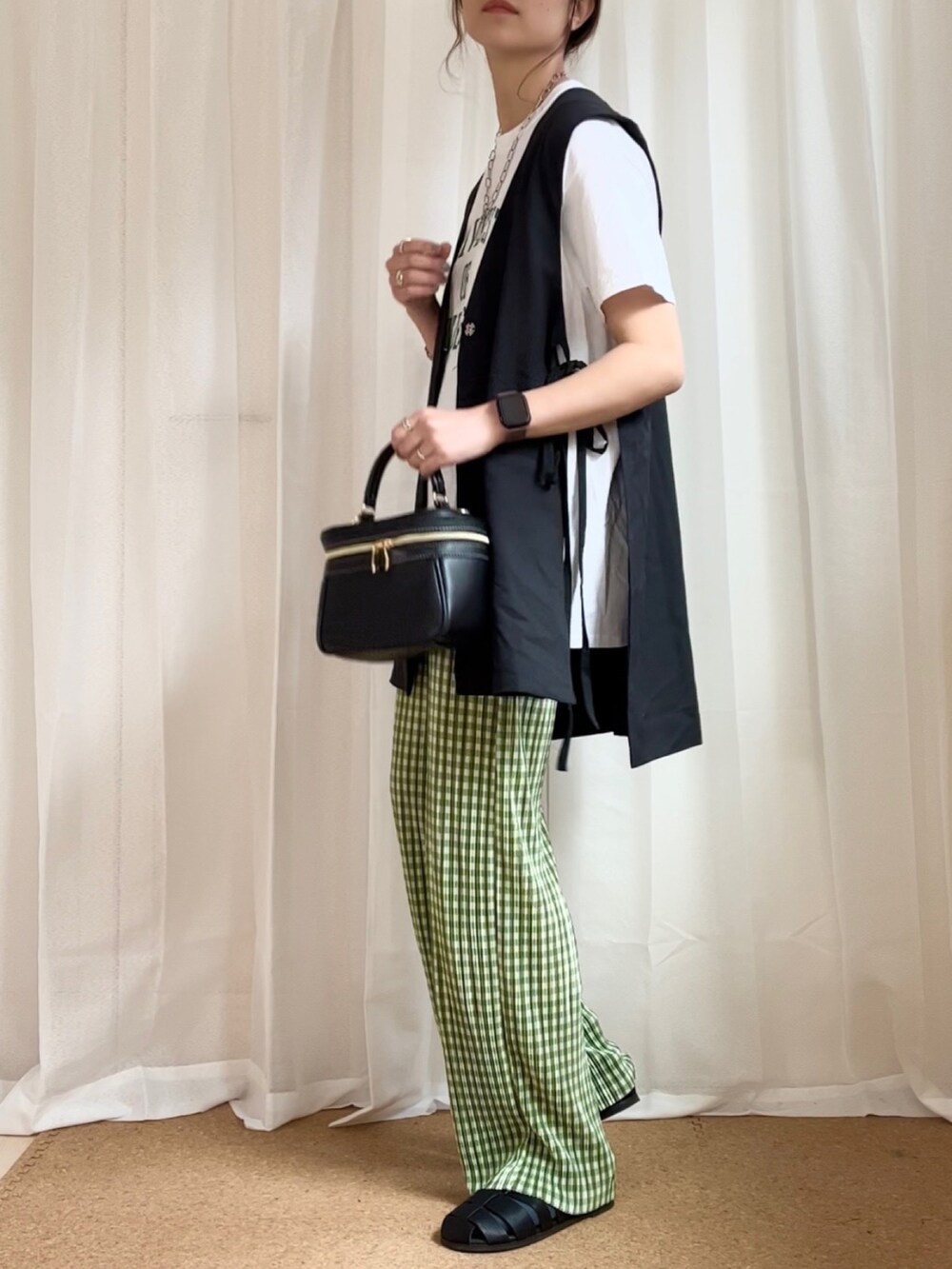 ブラック系のベスト、グリーン系のその他パンツ、ホワイト系のTシャツ/カットソーを着用したレディースの春コーディネートの2枚目の写真