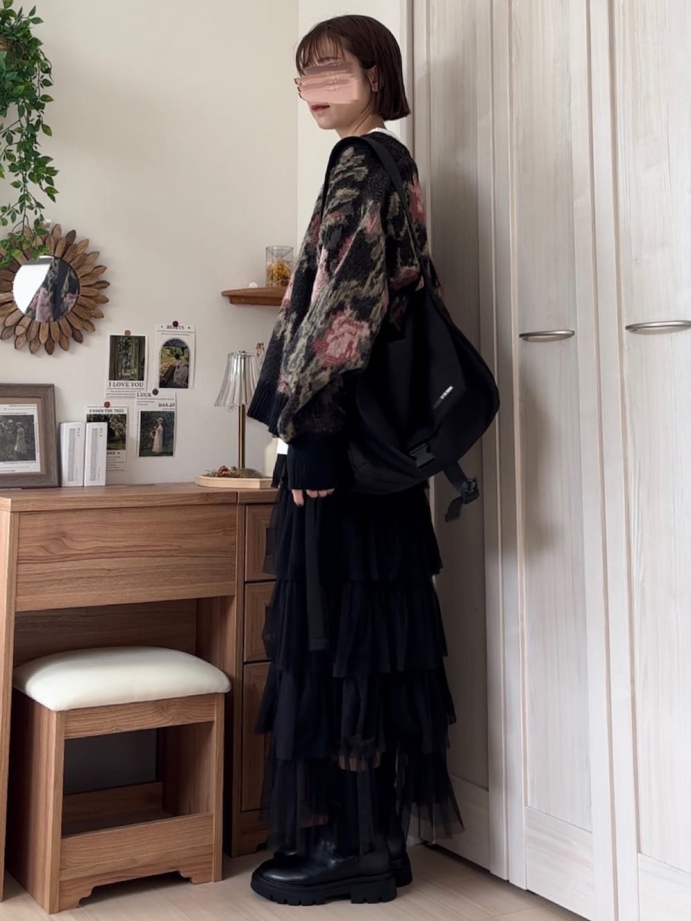 ブラック系のカーディガン/ボレロ、ブラック系のスカート、ブラック系のブーツを着用したレディースの秋コーディネートの3枚目の写真