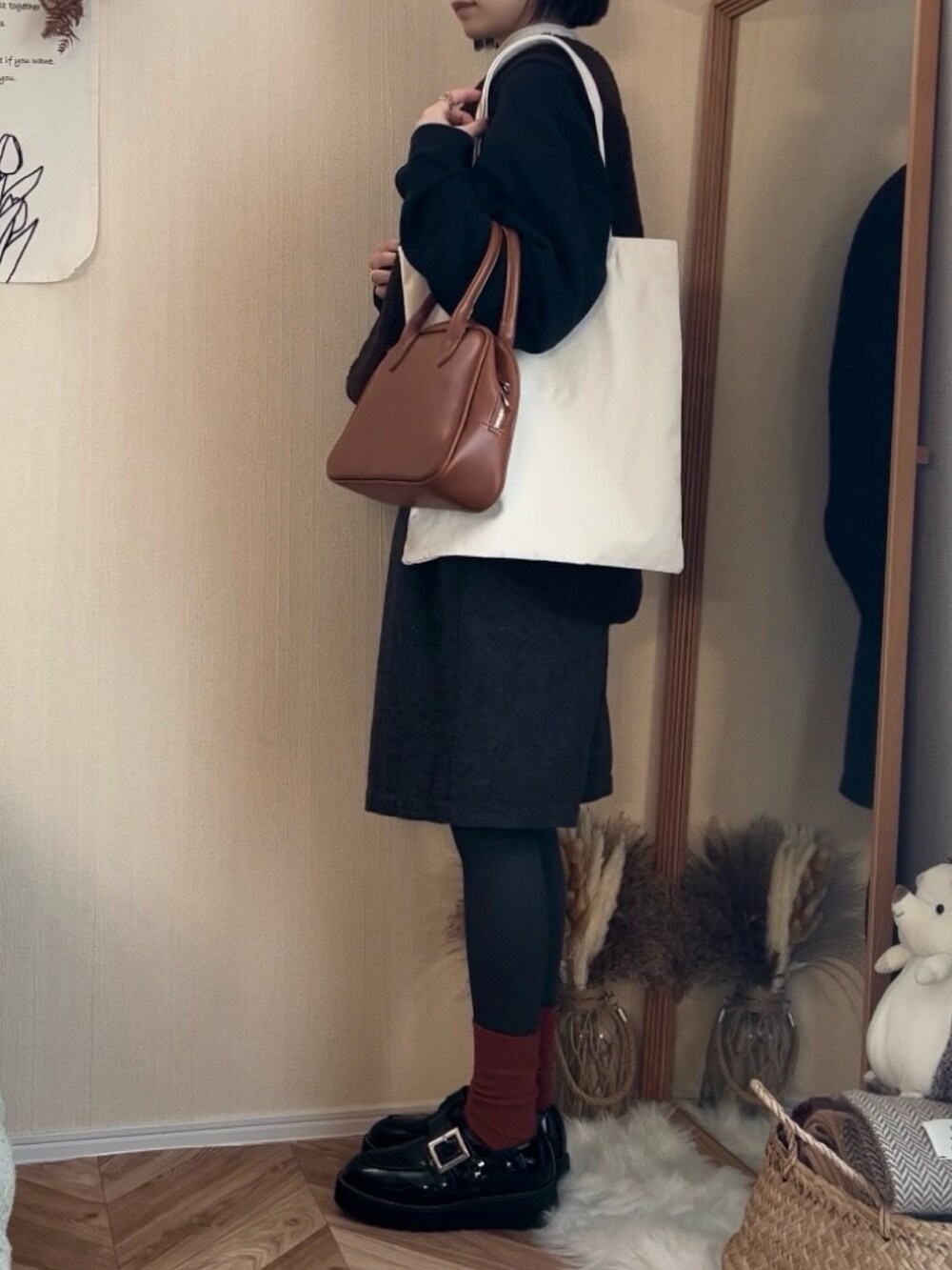 ブラック系のスウェット、ブラウン系のベスト、ブラウン系のその他パンツを着用したレディースの冬コーディネートの2枚目の写真