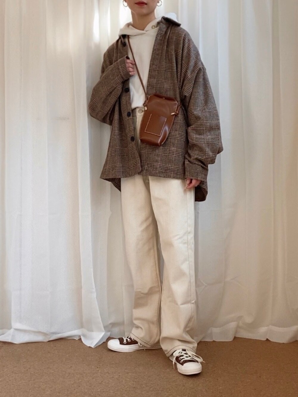 ベージュ系のシャツ/ブラウス、ホワイト系のパーカー、ベージュ系のデニムパンツを着用したレディースの冬コーディネートの2枚目の写真