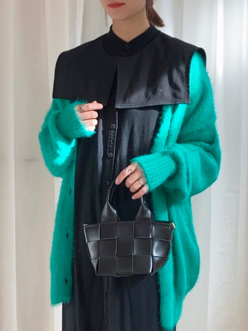 グリーン系のカーディガン/ボレロ、ブラック系のシャツワンピース、ブラック系のバッグを着用したレディースの冬コーディネートの3枚目の写真