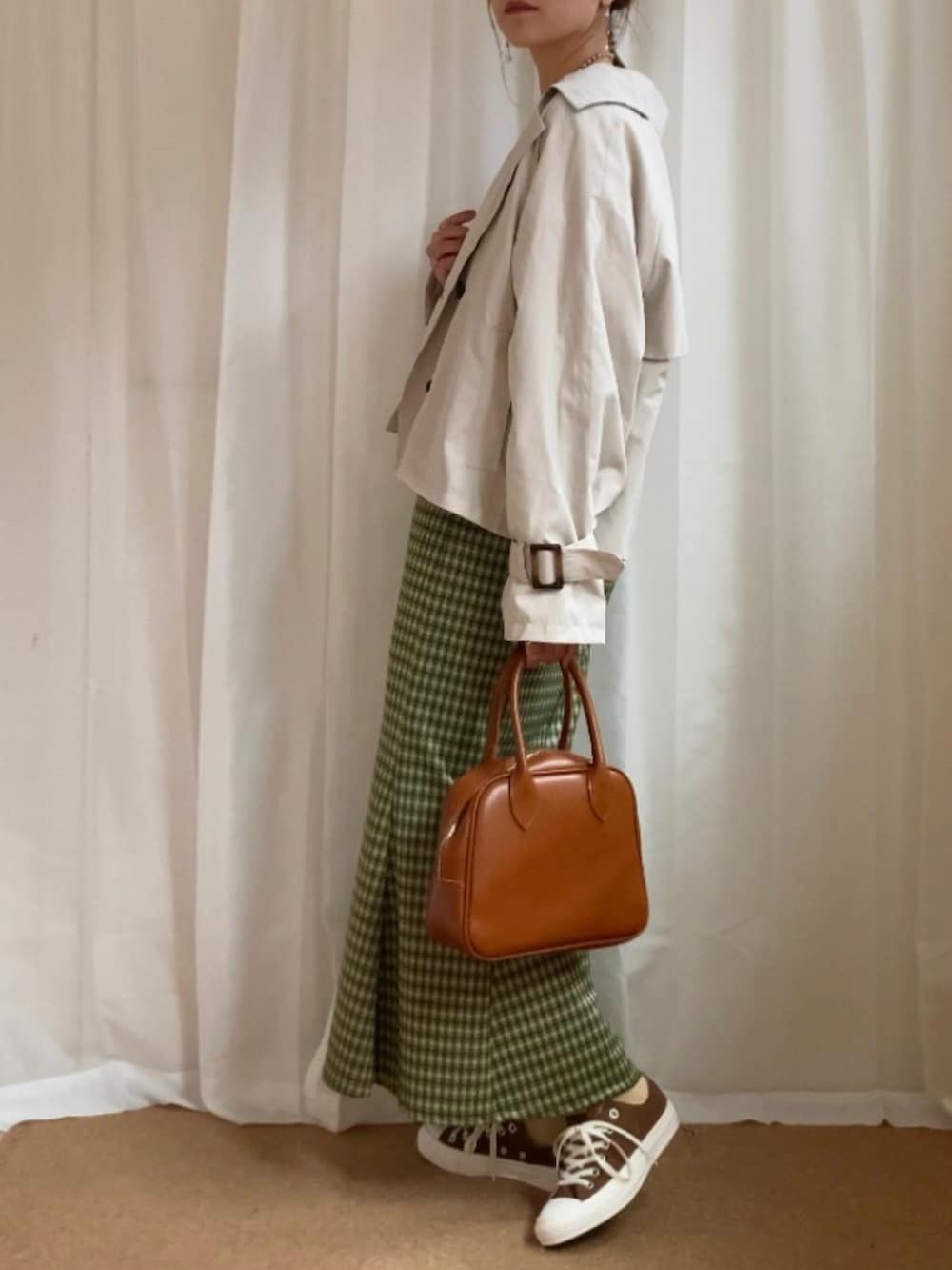 ホワイト系のトレンチコート、ホワイト系のTシャツ/カットソー、イエロー系のボストンバッグを着用したレディースの春コーディネートの2枚目の写真