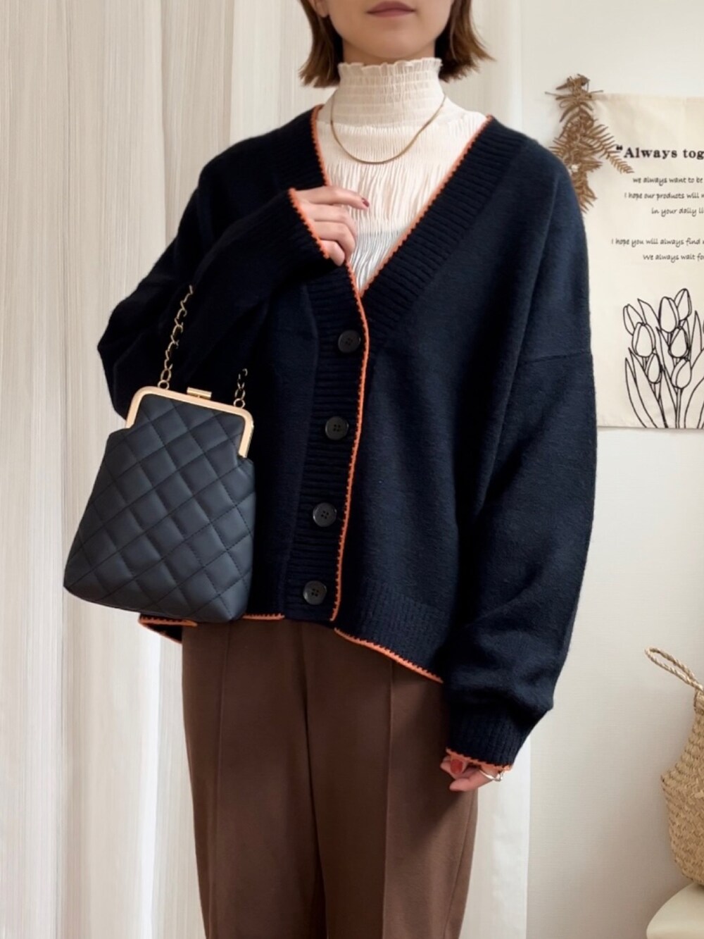 ブラック系のカーディガン/ボレロ、ブラック系のショルダーバッグ、ブラック系のパンプスを着用したレディースの秋コーディネートの2枚目の写真