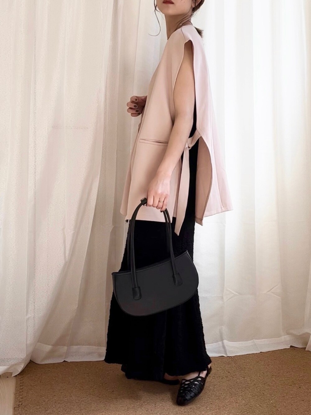 ブラック系のワンピース、ピンク系のベスト、ホワイト系のキャミソールを着用したレディースの夏コーディネートの2枚目の写真