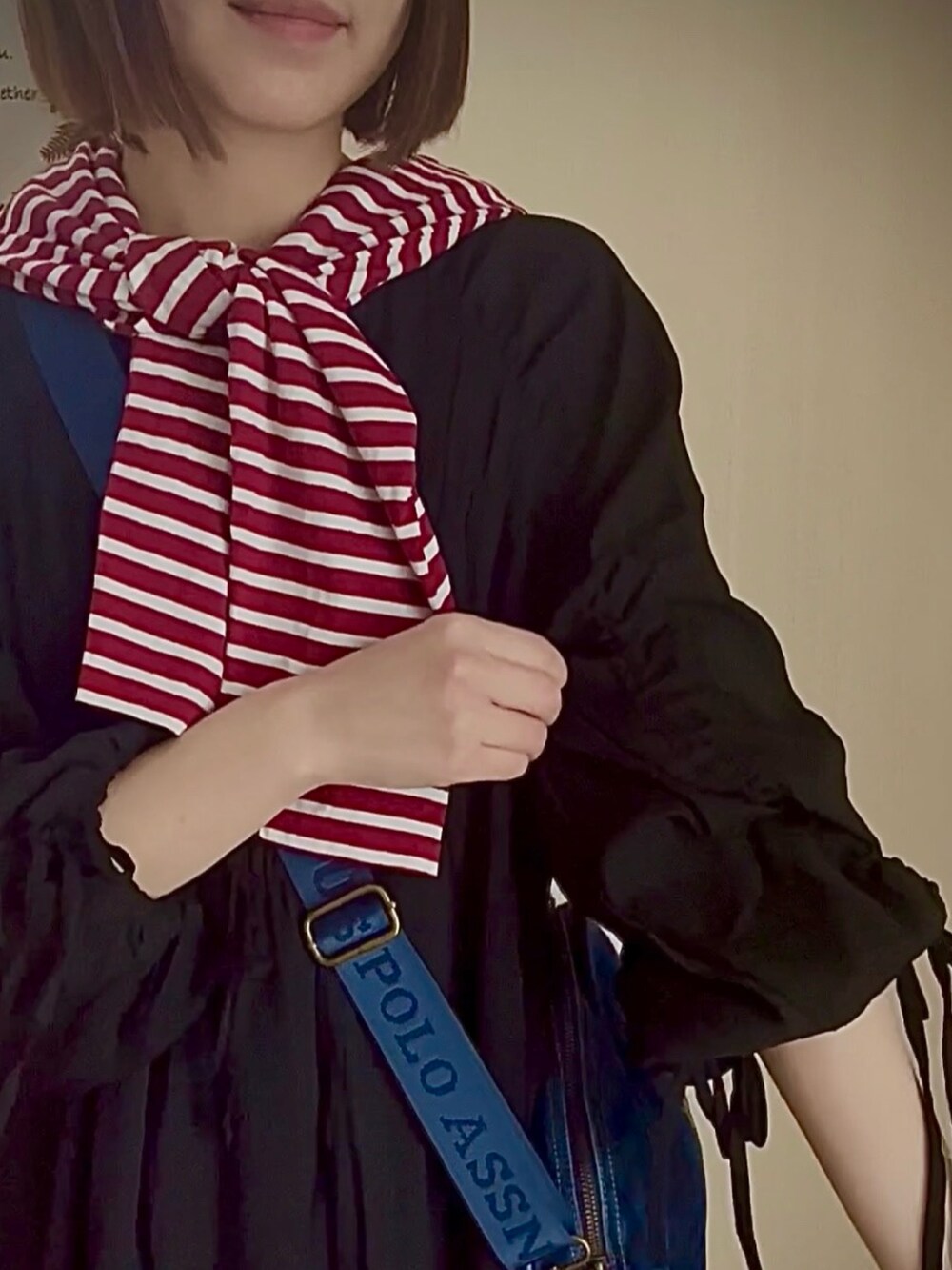 ブラック系のワンピース/ドレス、レッド系のTシャツ/カットソー、ブルー系のショルダーバッグを着用したレディースの春コーディネートの3枚目の写真