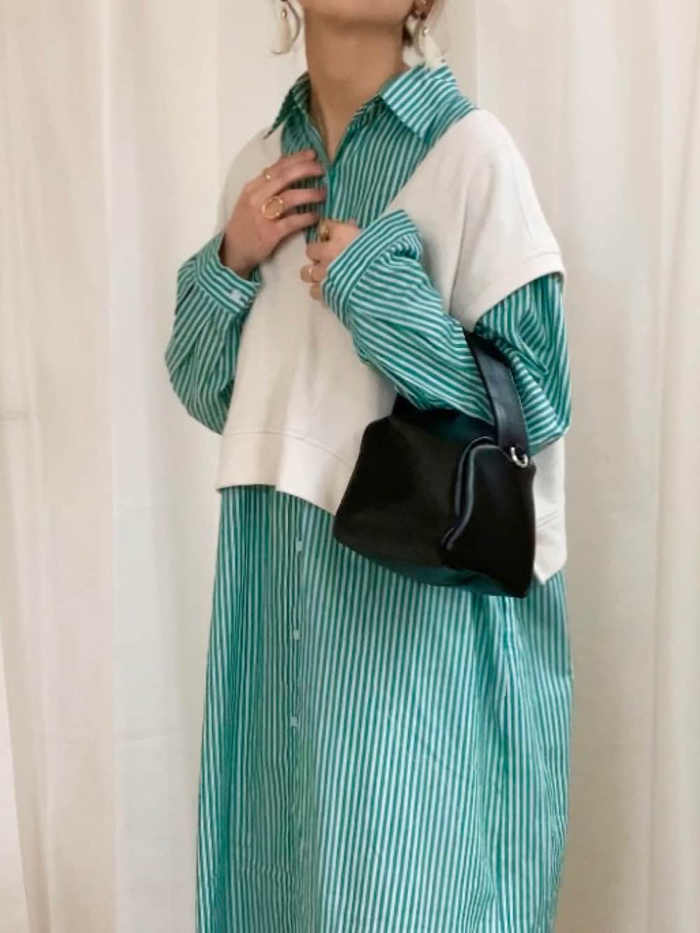 グリーン系のシャツワンピース、ブラック系のショルダーバッグ、ブラック系のスニーカーを着用したレディースの冬コーディネートの2枚目の写真