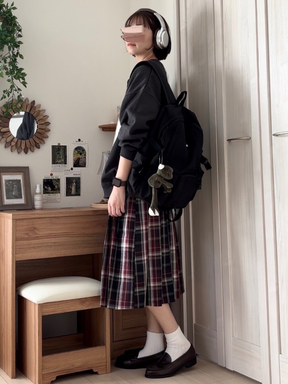 ブラック系のスウェット、ブルー系のスカート、ブラウン系のローファーを着用したレディースの秋コーディネートの2枚目の写真