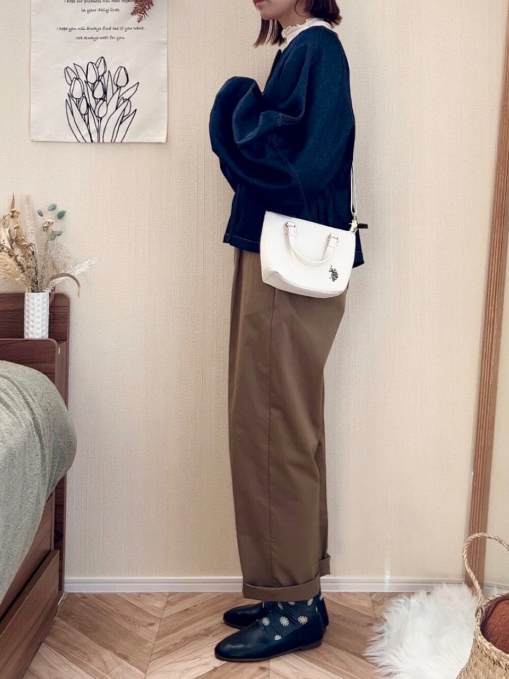 ホワイト系のショルダーバッグ、ブルー系のデニムジャケット、グリーン系のチノパンツを着用したレディースの秋コーディネートの3枚目の写真