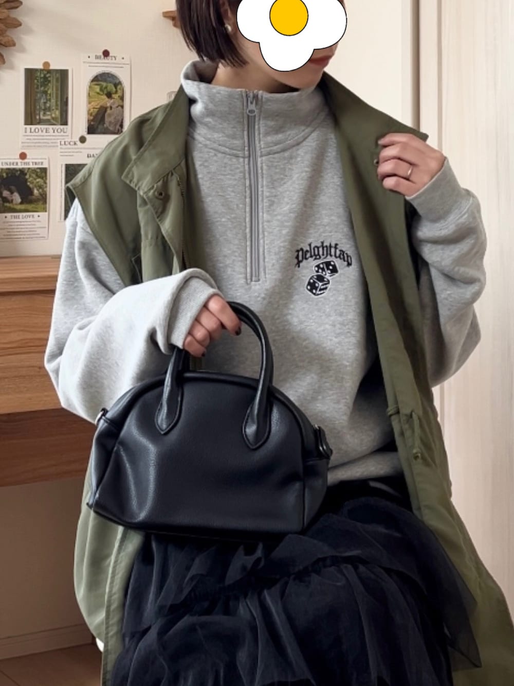 グレー系のスウェット、グリーン系のベスト、ブラック系のスカートを着用したレディースの春コーディネートの2枚目の写真