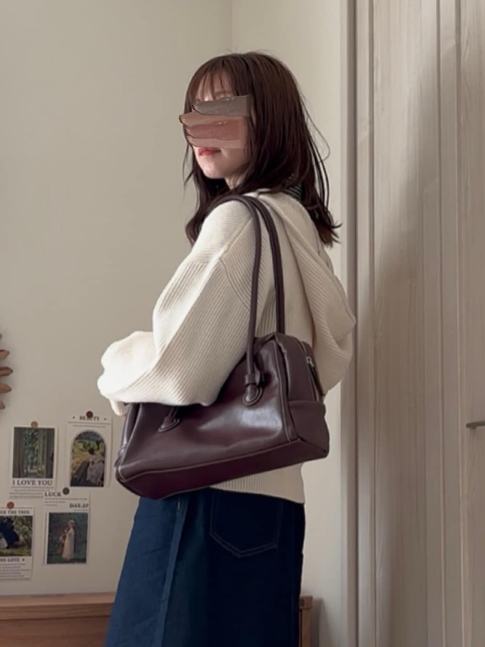 ホワイト系のパーカー、ブルー系のデニムスカートを着用したレディースの冬コーディネートの3枚目の写真