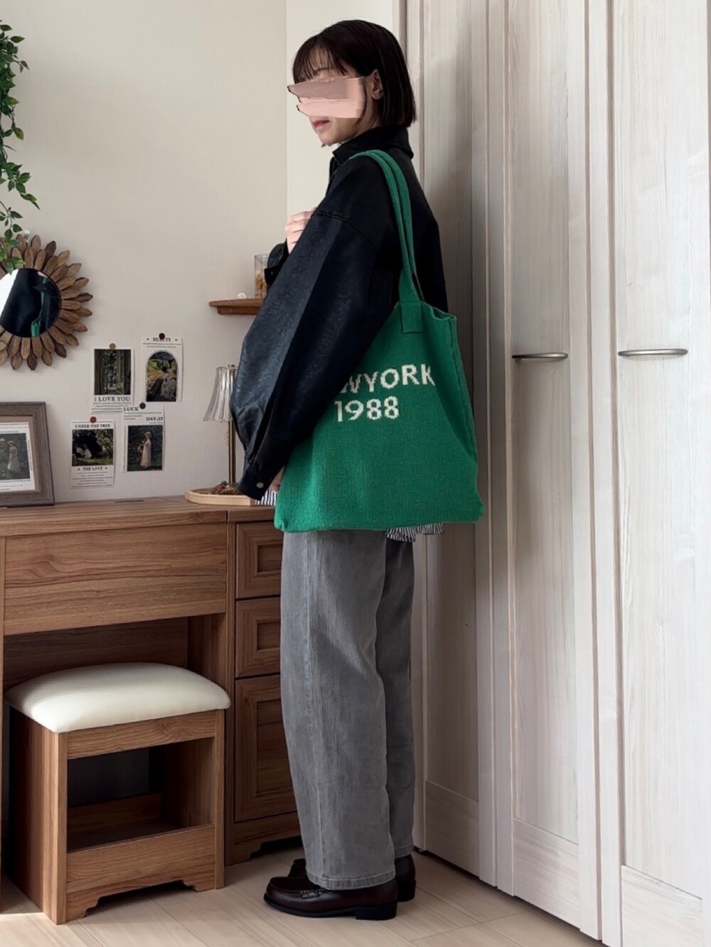 ブラック系のブルゾン、ブルー系のシャツ/ブラウス、グレー系のデニムパンツを着用したレディースの秋コーディネートの2枚目の写真