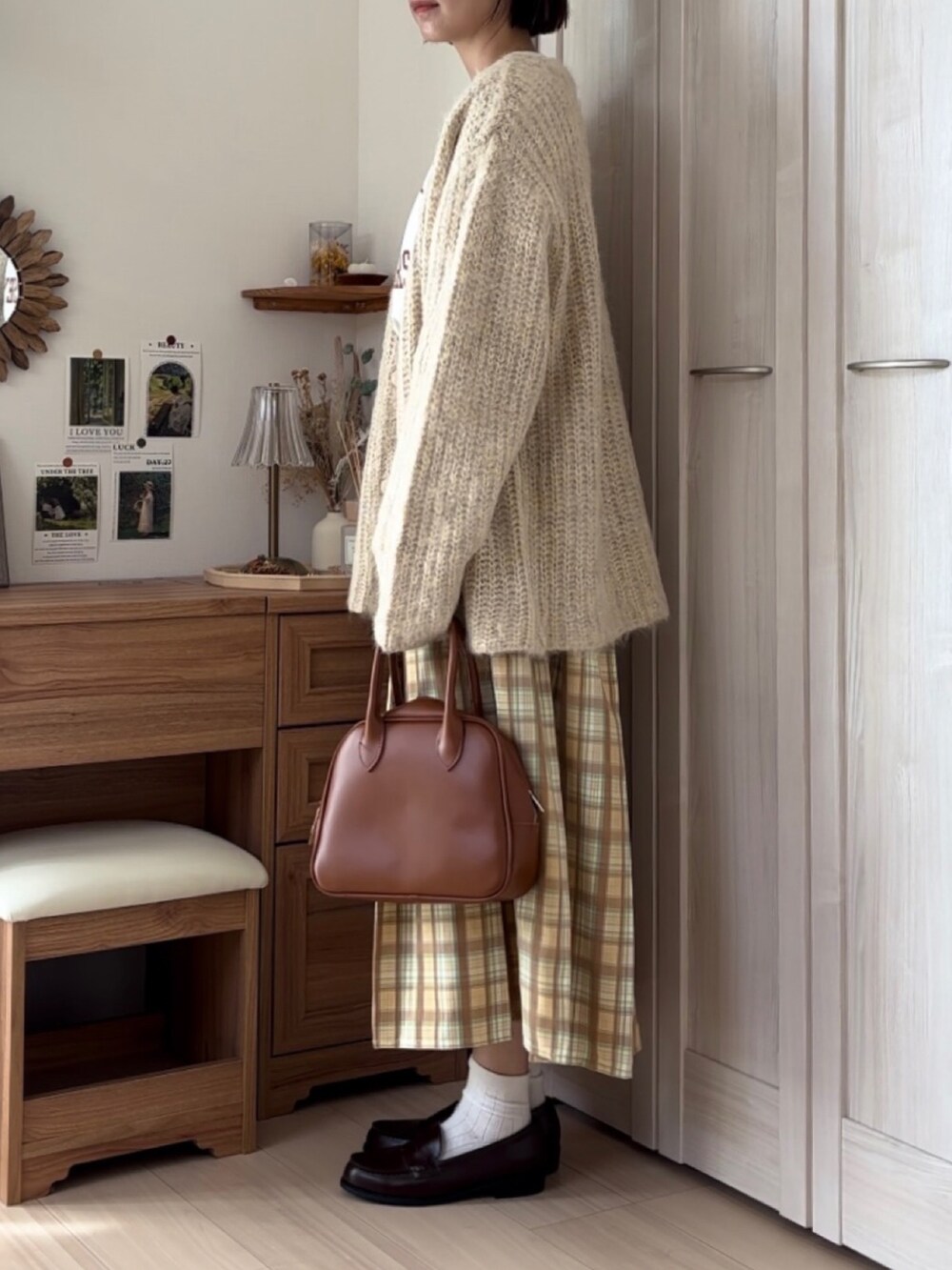 ベージュ系のカーディガン/ボレロ、ベージュ系のTシャツ/カットソー、イエロー系のスカートを着用したレディースの秋コーディネートの2枚目の写真