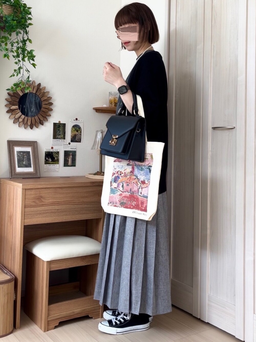 グレー系のTシャツ/カットソー、ブラック系のカーディガン/ボレロ、グレー系のスカートを着用したレディースの春コーディネートの3枚目の写真