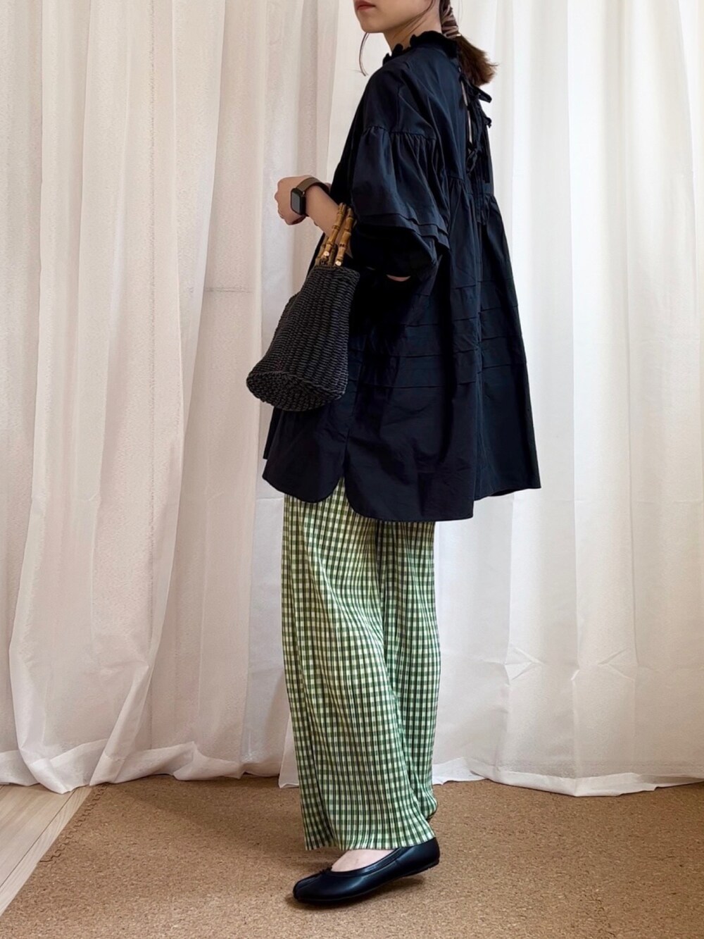 ブラック系のシャツ/ブラウス、グリーン系のその他パンツ、ブラック系のハンドバッグを着用したレディースの春コーディネートの2枚目の写真