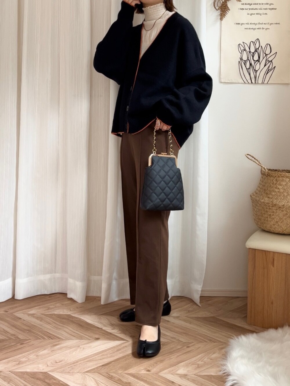 ブラック系のカーディガン/ボレロ、ブラック系のショルダーバッグ、ブラック系のパンプスを着用したレディースの秋コーディネートの4枚目の写真