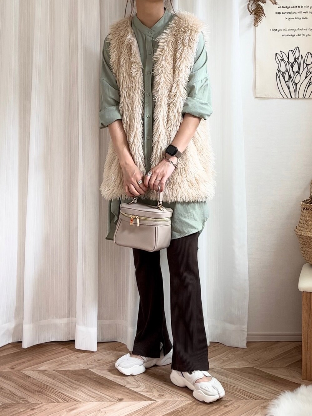 ホワイト系のベスト、グリーン系のシャツ/ブラウス、ホワイト系のサンダルを着用したレディースの夏コーディネートの2枚目の写真